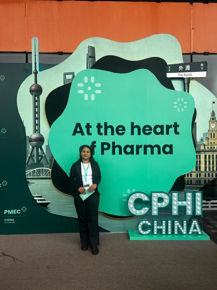 A PharmExpert colleague in front of the CPHI China 'At the heart of Pharma' display