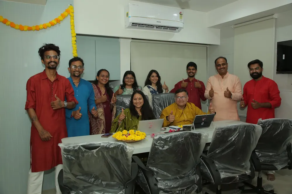 Team gathered around a decorated table for a celebration in the office
