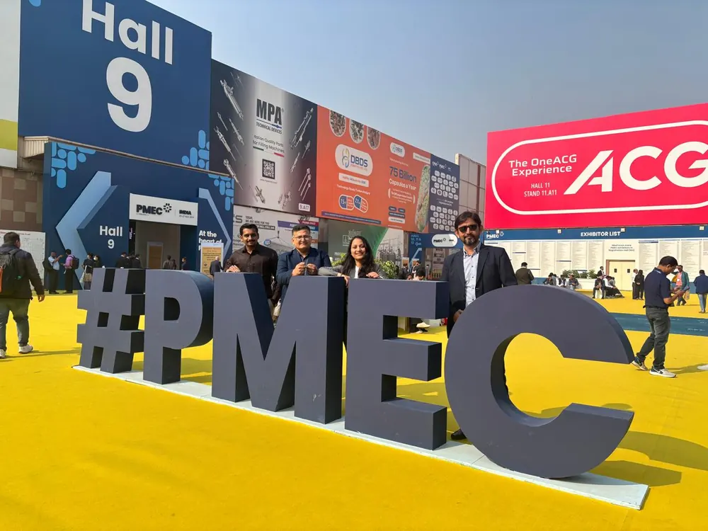 Colleagues beside the PMEC lettering outside an exhibition hall