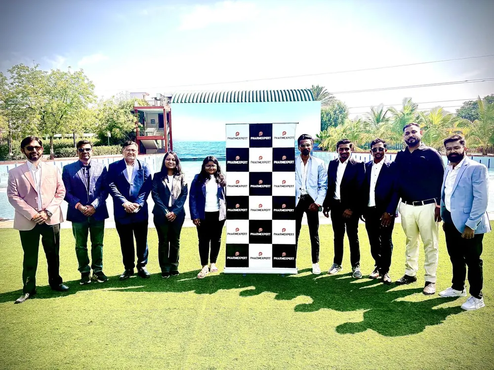 PharmExpert colleagues lined up in front of a branded step-and-repeat banner at a company event