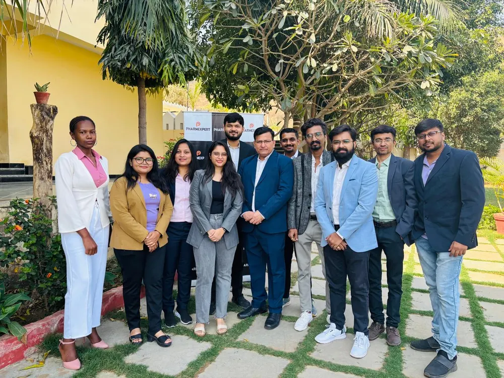 PharmExpert team in business dress photographed together in a garden